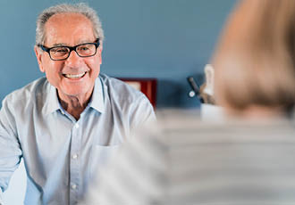 Homme âgé malvoyant portant des lunettes dans un point expert basse vision Optic 2000